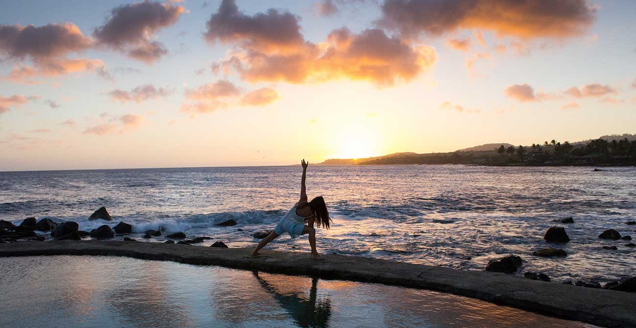 A lady doing yoga on a beach