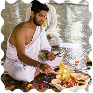 A person doing fire ritual at India Yoga School