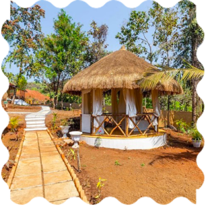 A straw hut with a walkway in the middle of it at India Yoga School.