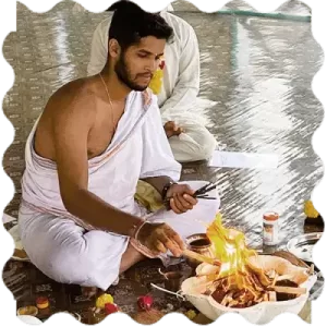 A person doing fire ritual at India Yoga School
